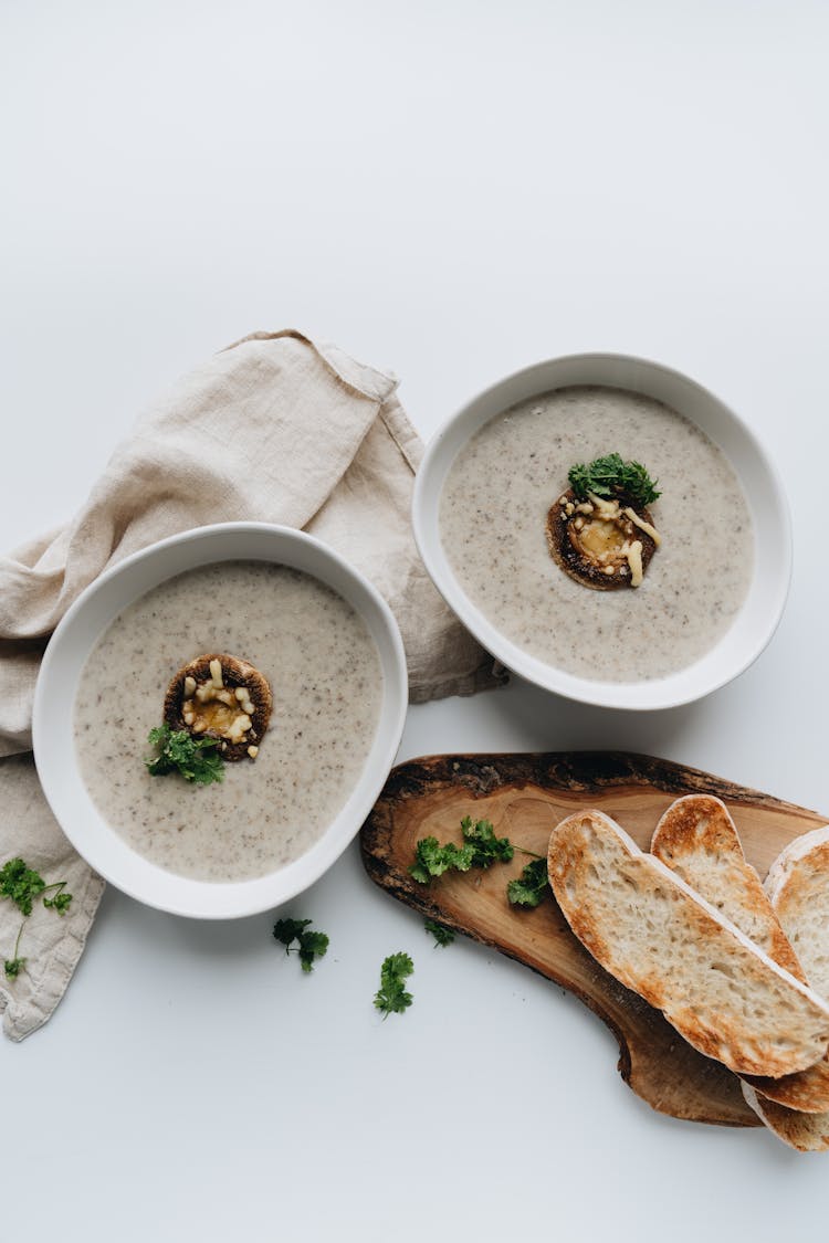 Sliced Bread Beside Bowls Of Soup