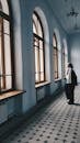 Woman standing in spacious hallway and looking out window
