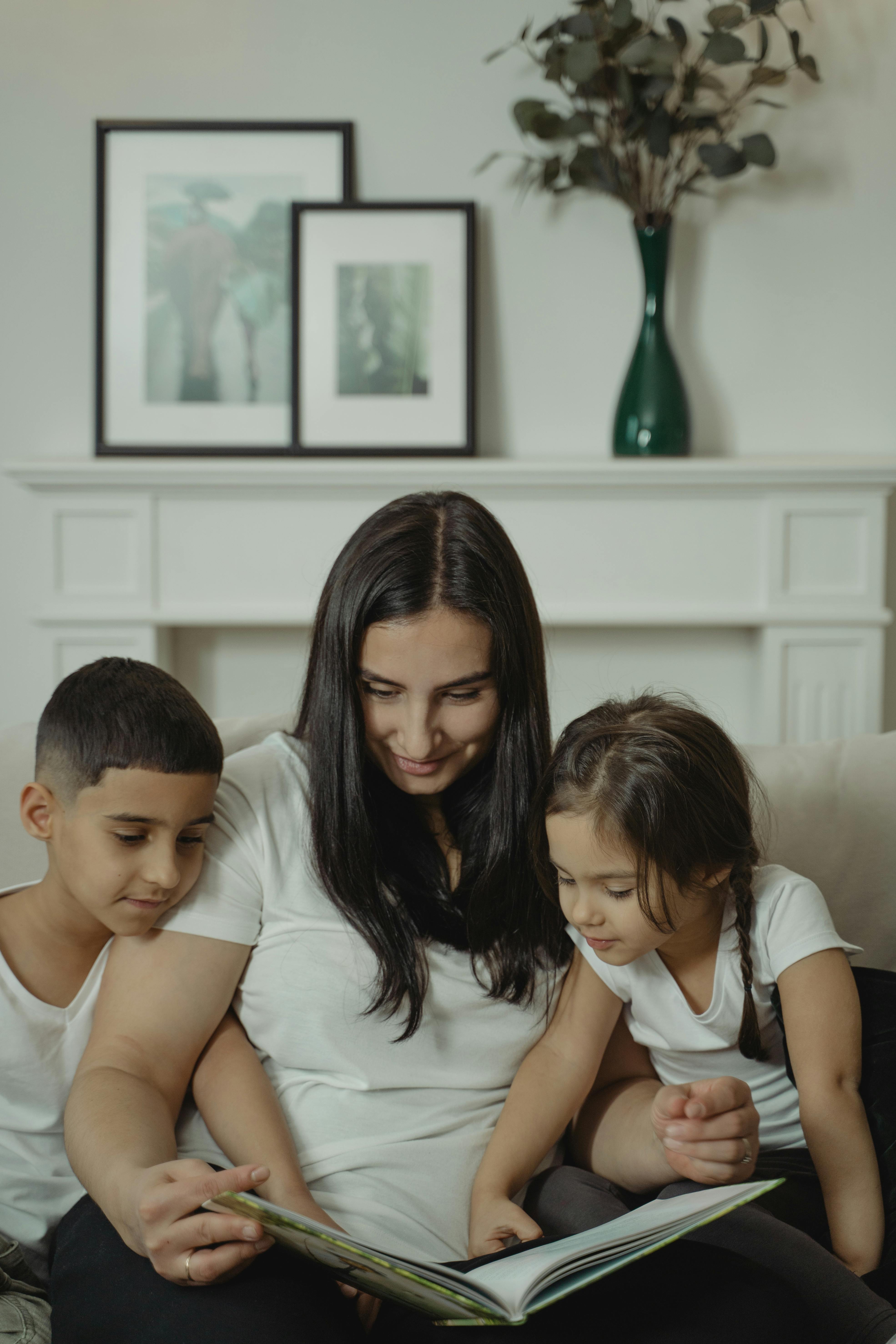 woman and children reading a book together