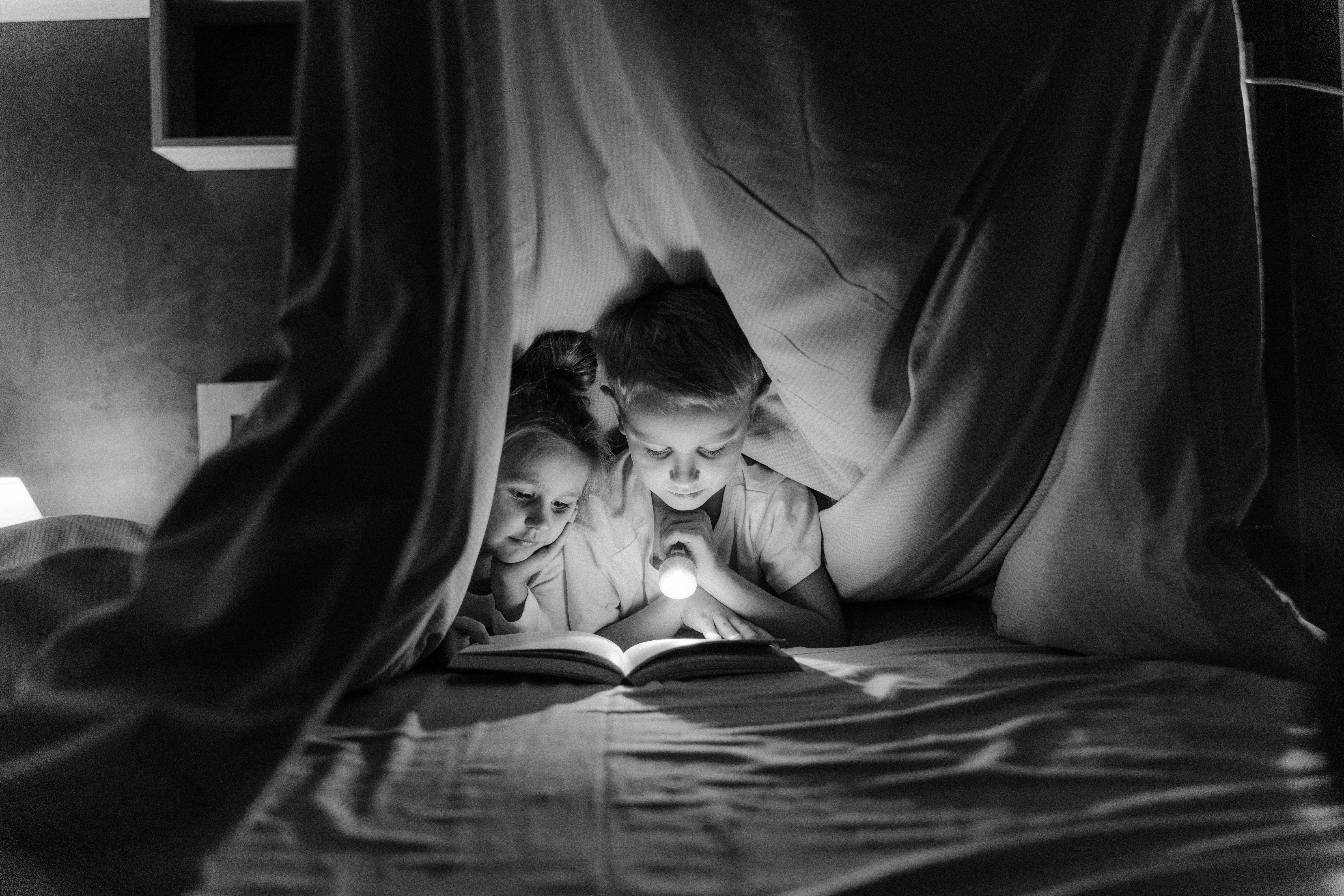 grayscale photo of woman lying on bed