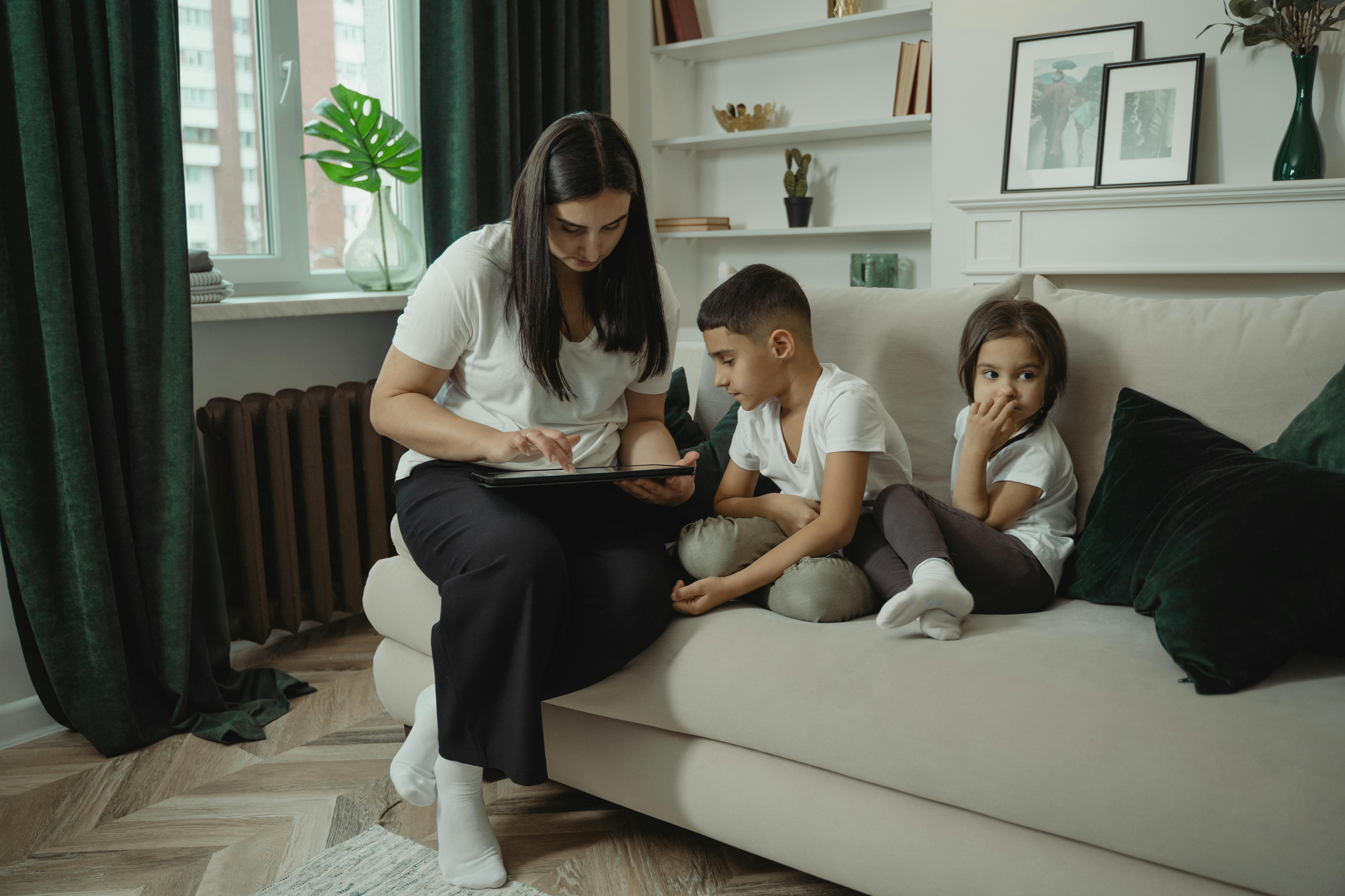 a mother using digital tablet with her children