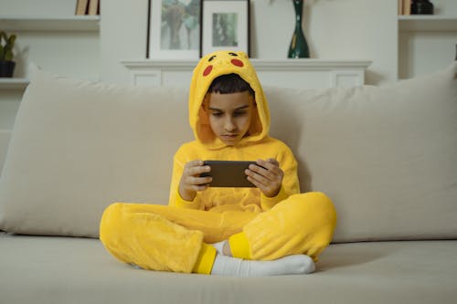 Young Boy wearing Costume using Smartphone