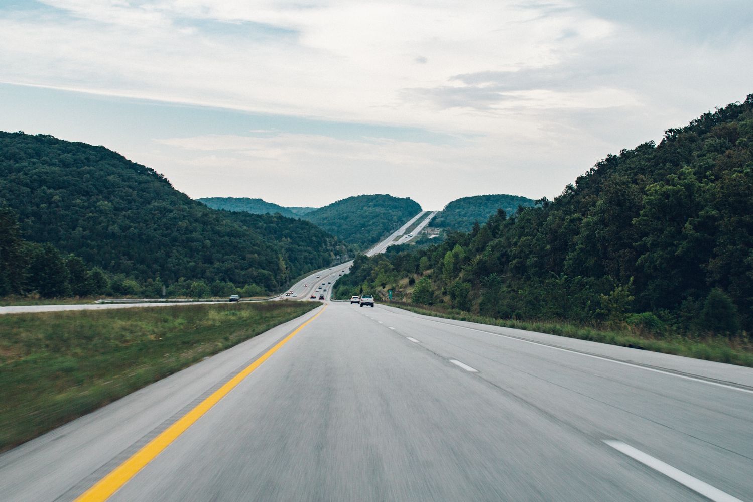Open highway at sunrise with mountains in the distance — the start of a Memorial Day road trip