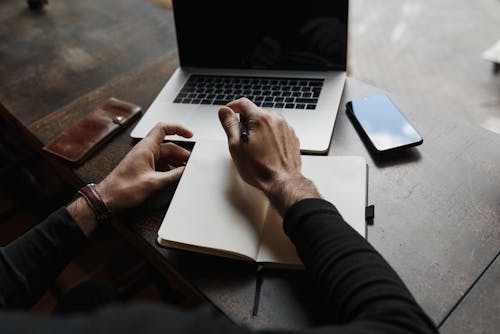 A Perso holding Pen and Notebook