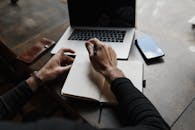 A Perso holding Pen and Notebook