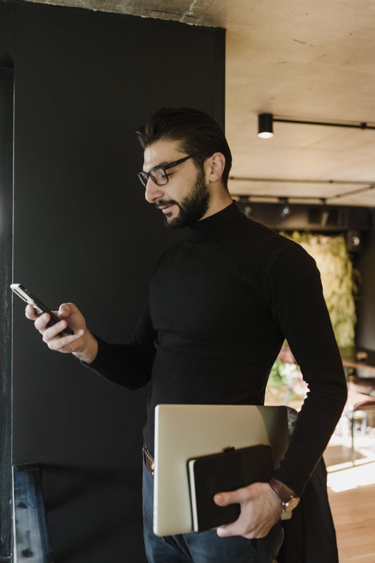 A Businessman Holding And Looking At His Smartphone 