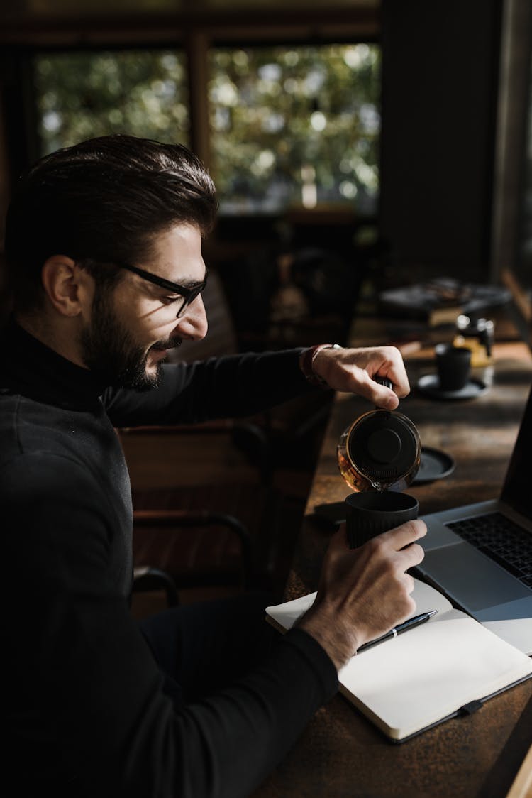 A Man Pouring Tea In The Cup