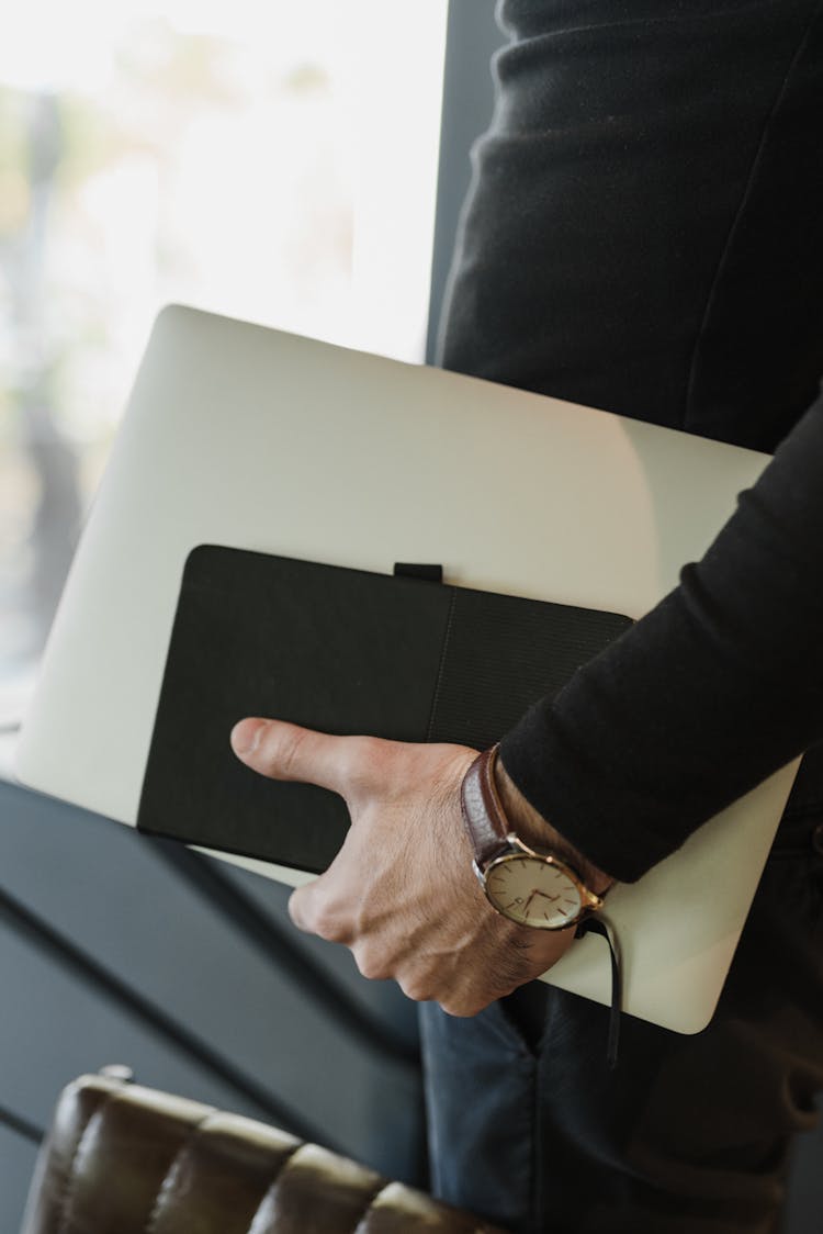 A Person Carrying Laptop And Notebook