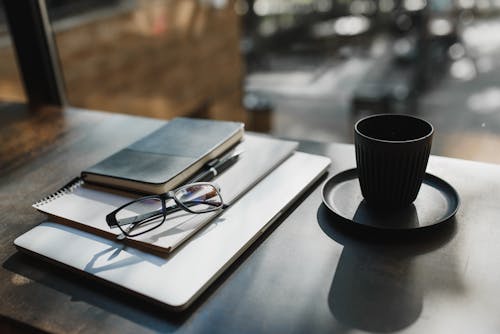 Black Cup with Saucer on Brown Surface