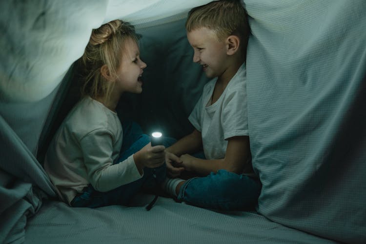 Boy And Girl In Blanket Fort Laughing 