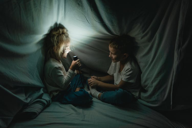 Girl And Boy Laughing In Blanket Fort