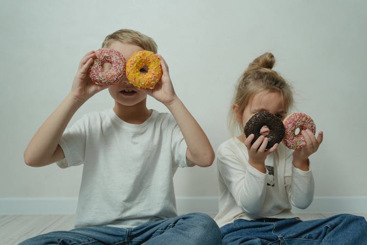 Girl And Boy Fooling Around With Doughnuts