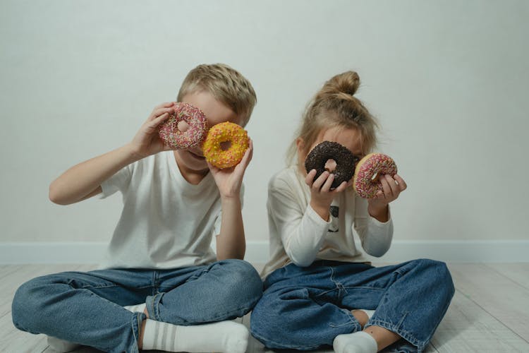 Girl And Boy Fooling Around With Doughnuts