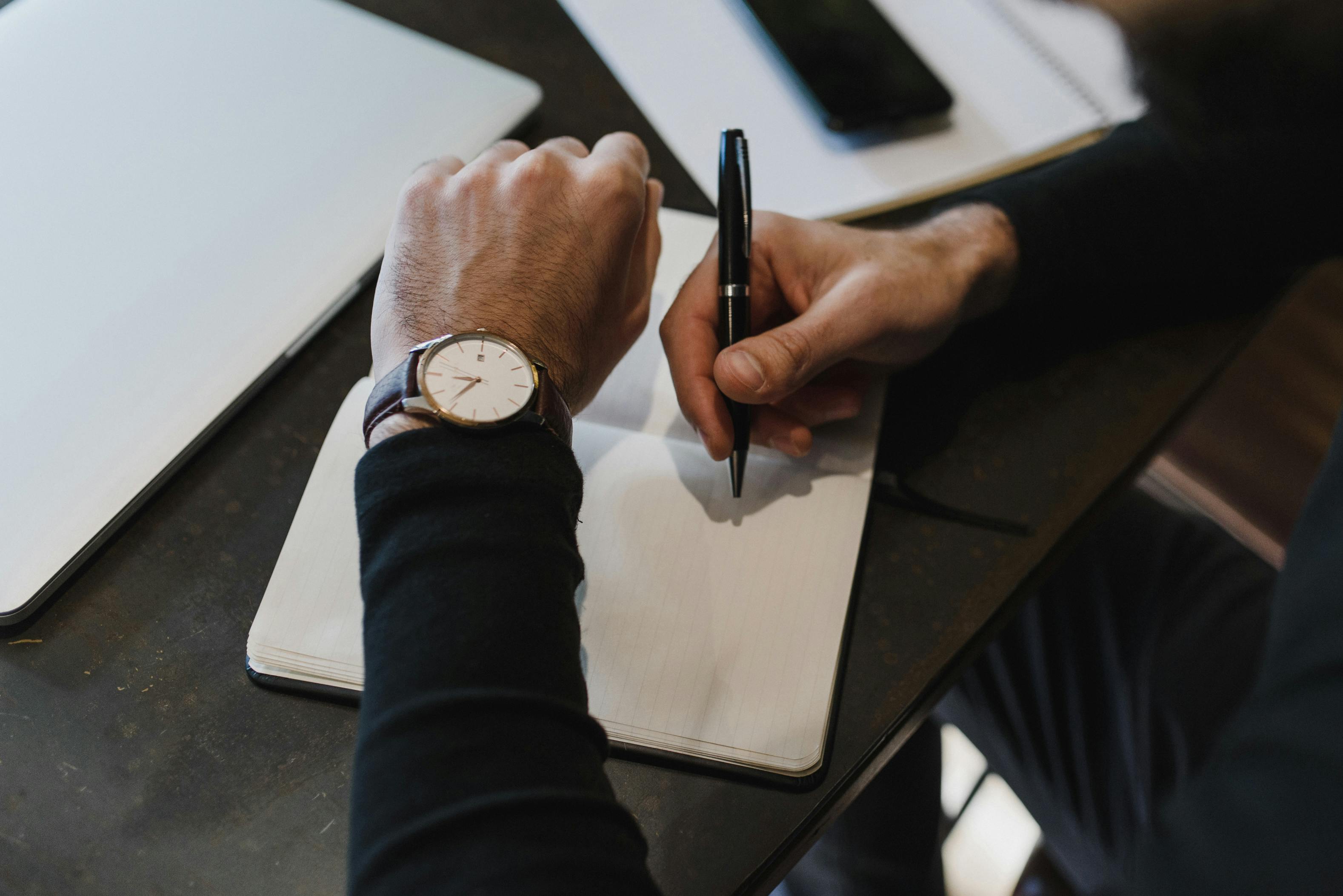 A Person holding a Pen while Looking the Watch