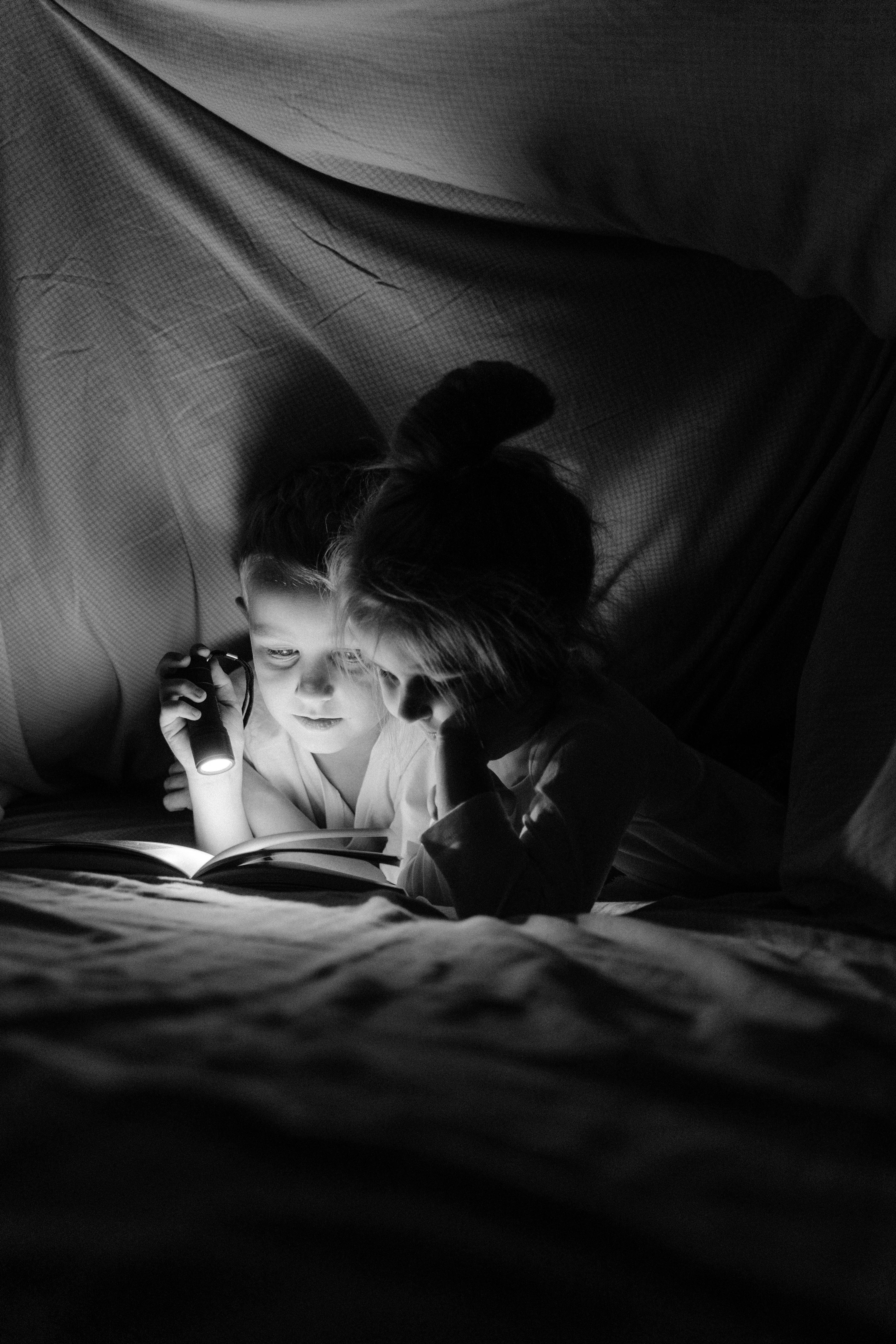 grayscale photo of woman lying on bed