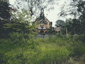 这座风景如画的教堂坐落在郁郁葱葱的绿色乡村中，四周环绕着充满活力的树叶，头顶是晴朗的天空