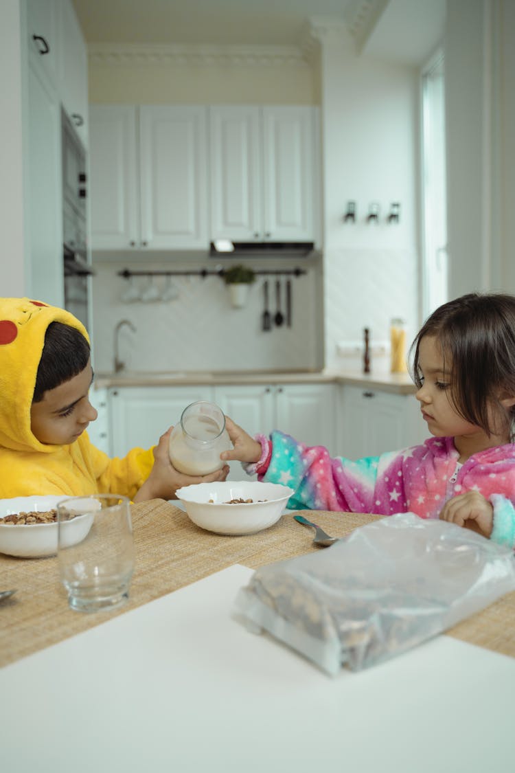 Children Holding A Bottle Of Milk Together