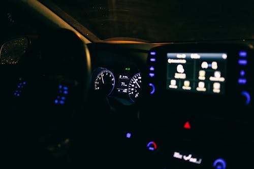 Illuminated dashboard of contemporary car parked on street in evening