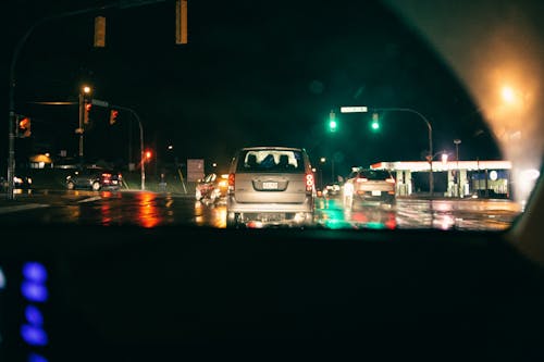 Various modern cars driving on road at night