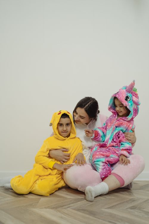 Free Mother and children in cute animal costumes enjoying quality time indoors. Stock Photo