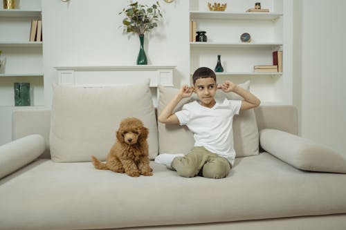 Woman in White T-shirt and Brown Shorts Sitting on White Couch