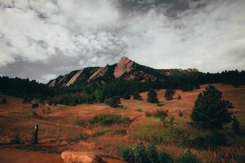 A large boulder rock formation under a cloudy sky
