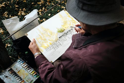 Man Sitting on Grass While Painting
