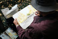 Man Sitting on Grass While Painting