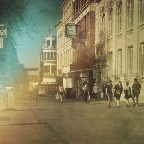 Free A bustling vintage-style city street with shoppers and historic architecture. Stock Photo