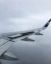 Airplane Wing Seen from Passenger Window with Raindrops