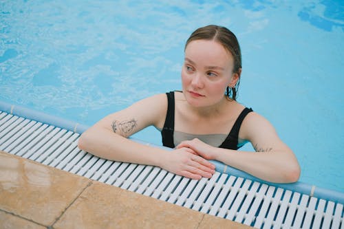 Young Woman with Tattoos Leaning at the Poolside