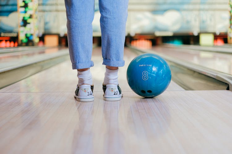 Close-up View Of Child Legs And Bowling Ball