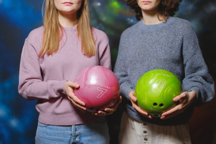 Women Holding Bowling Balls 