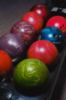 Close-up of various colorful bowling balls lined up ready for play.