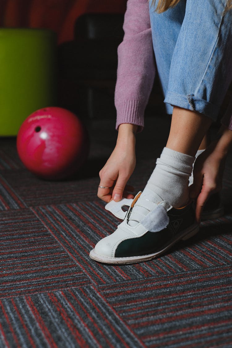 Close-up Of A Woman Putting On Bowling Shoes