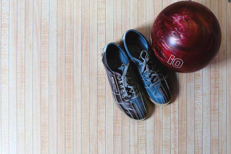 Bowling Shoes And Ball On Wooden Background