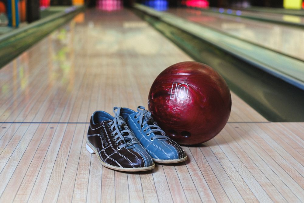 Bowling ball and shoes ready on a wooden lane