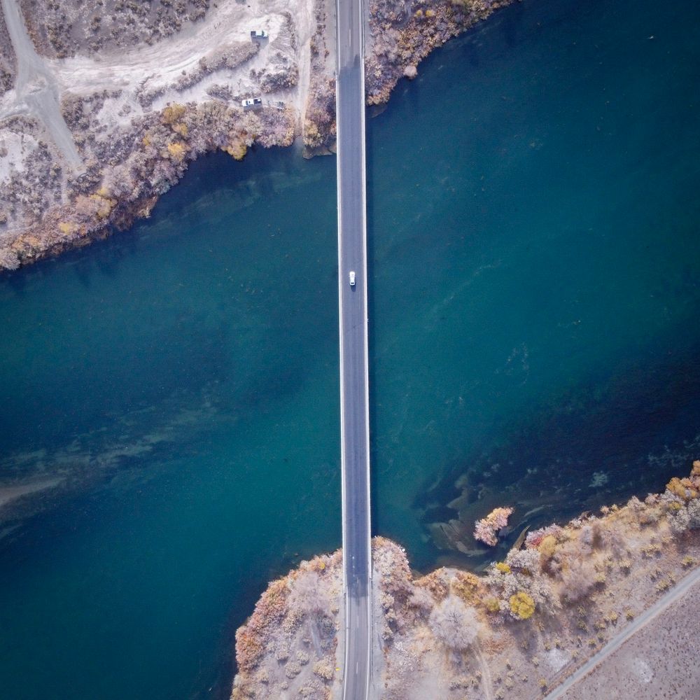 Car crossing a bridge over water seen from the air