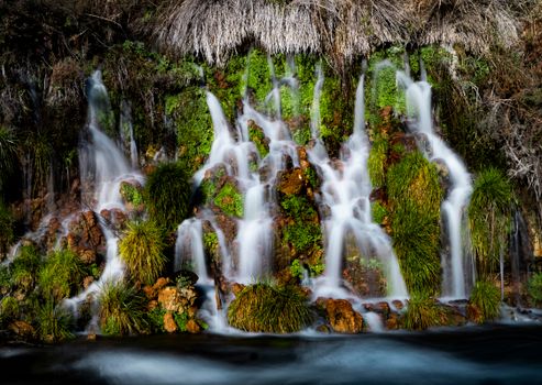Beautiful cascading waterfalls flowing over mossy rocks in an Idaho forest landscape.