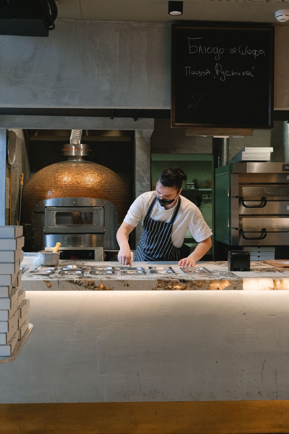 Cuisinier préparant une pizza dans une cuisine professionnelle