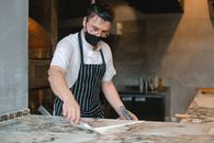 A Man Scraping the Flour from the Countertop