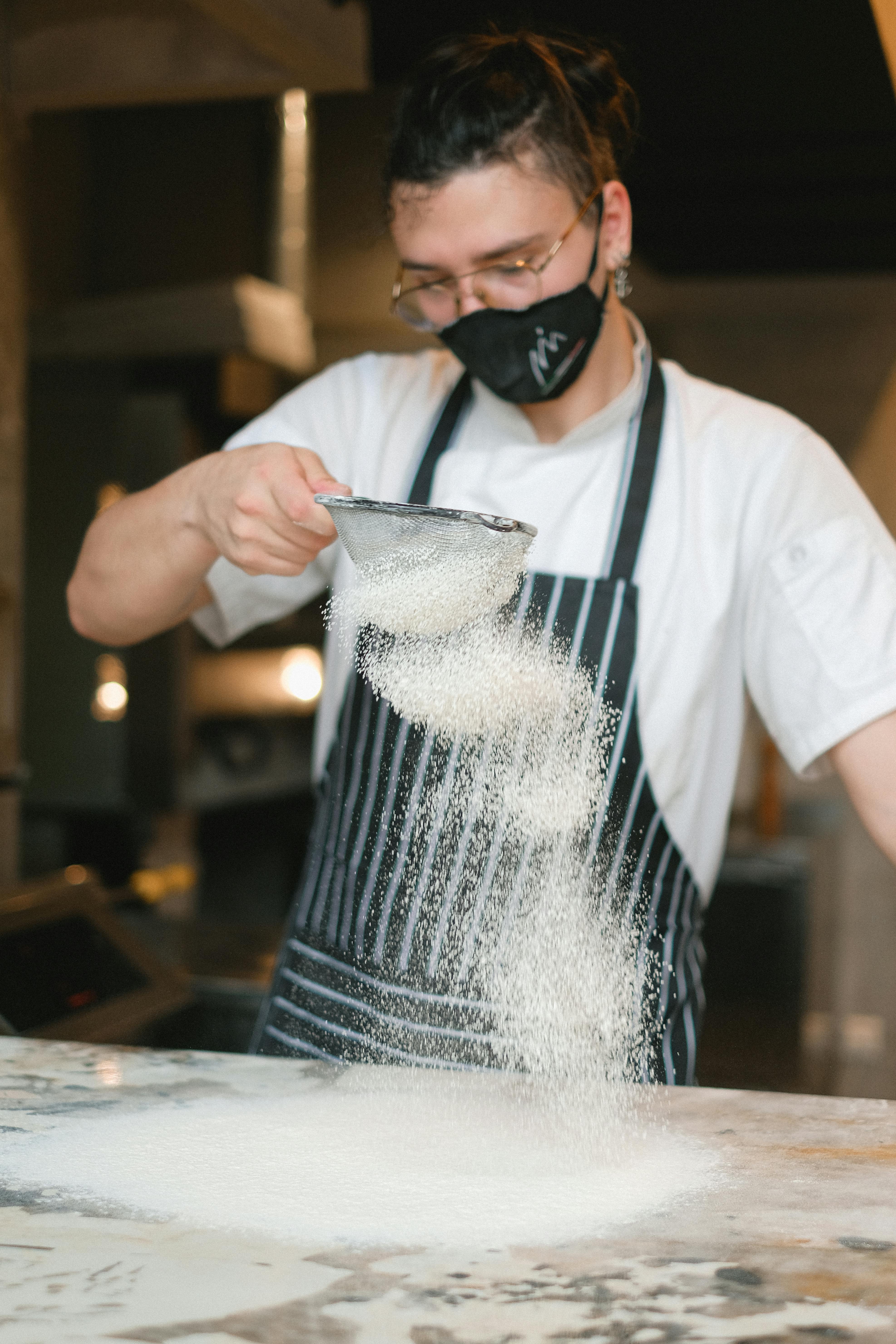 man wearing apron holding a strainer