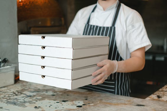 A Person Holding Boxes of Pizza