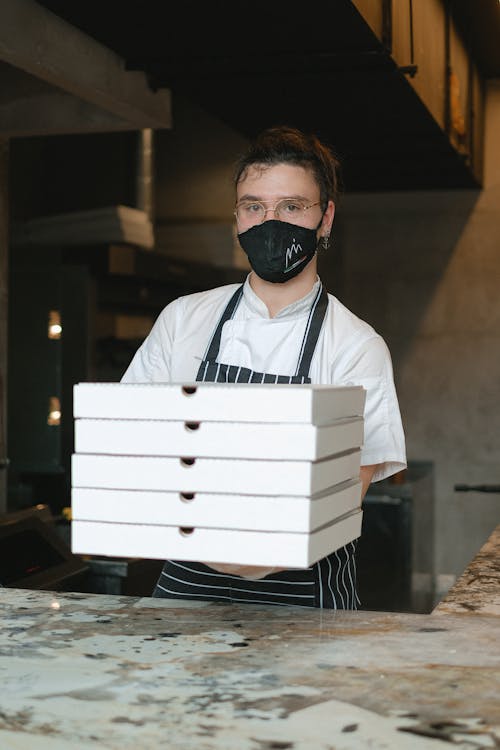 A Man Holding Boxes of Pizza 