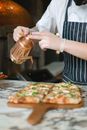A Person Drizzling Oil on a Pizza