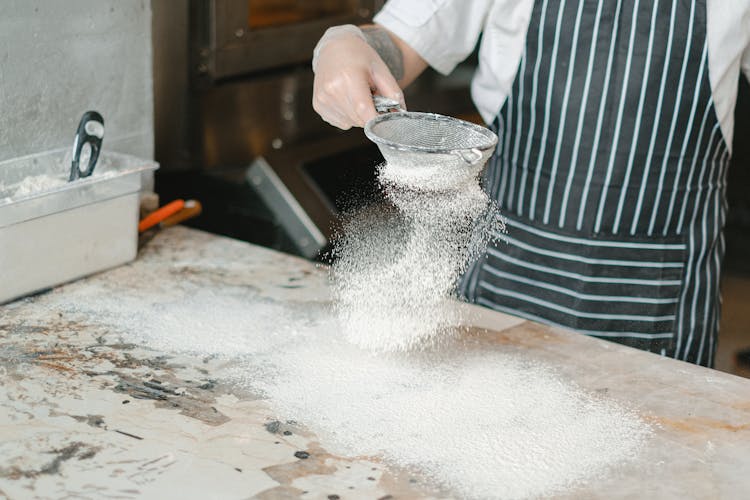 Man Sifting Flour On A Table