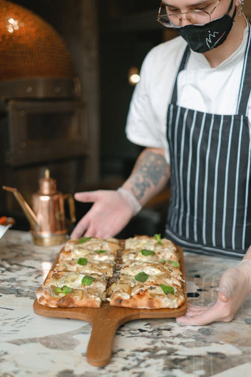 A Chef Serving a Square Pizza