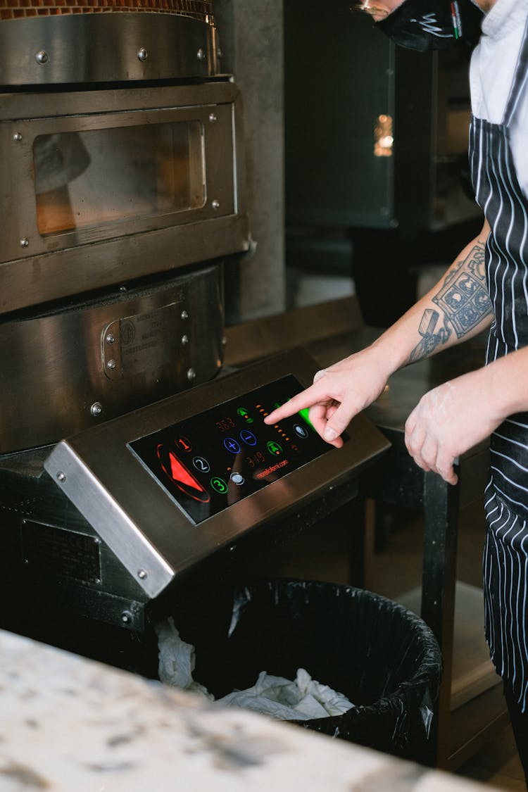 Cook Operating Oven At Restaurant