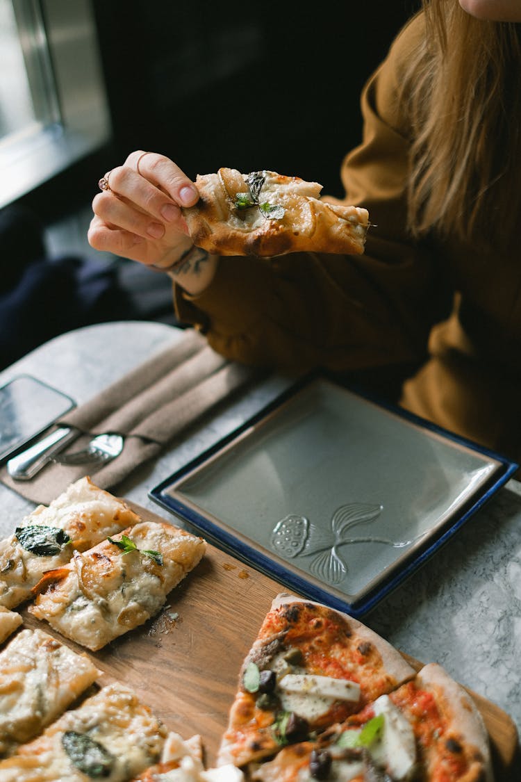 A Person Eating A Pizza