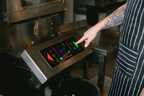 Person Turning On Machine at Manufactory